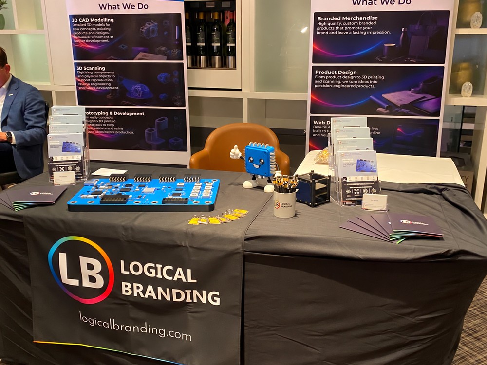 Logical Branding exhibitor stand at FPGA Horizons London 26 with a smaller Explorer Board replica, mascot figure and mugs